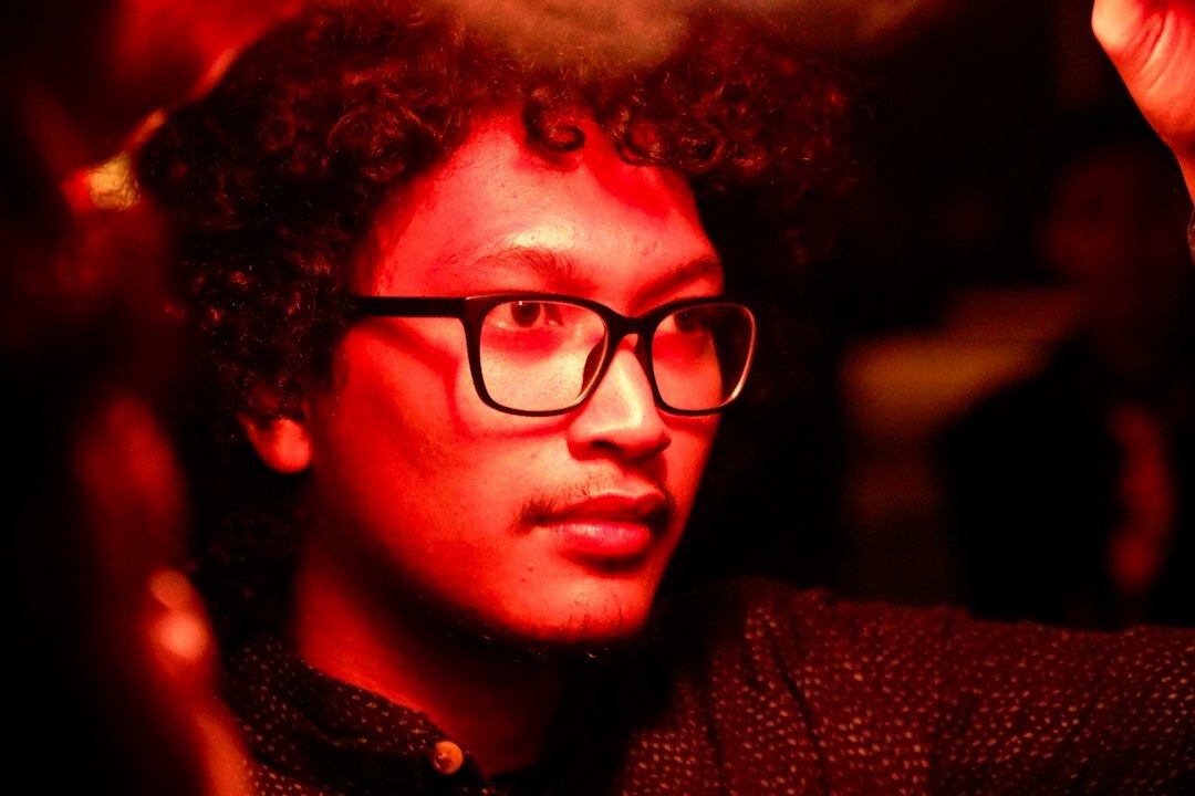 Portrait of an events coordinator, man with curly hair and glasses